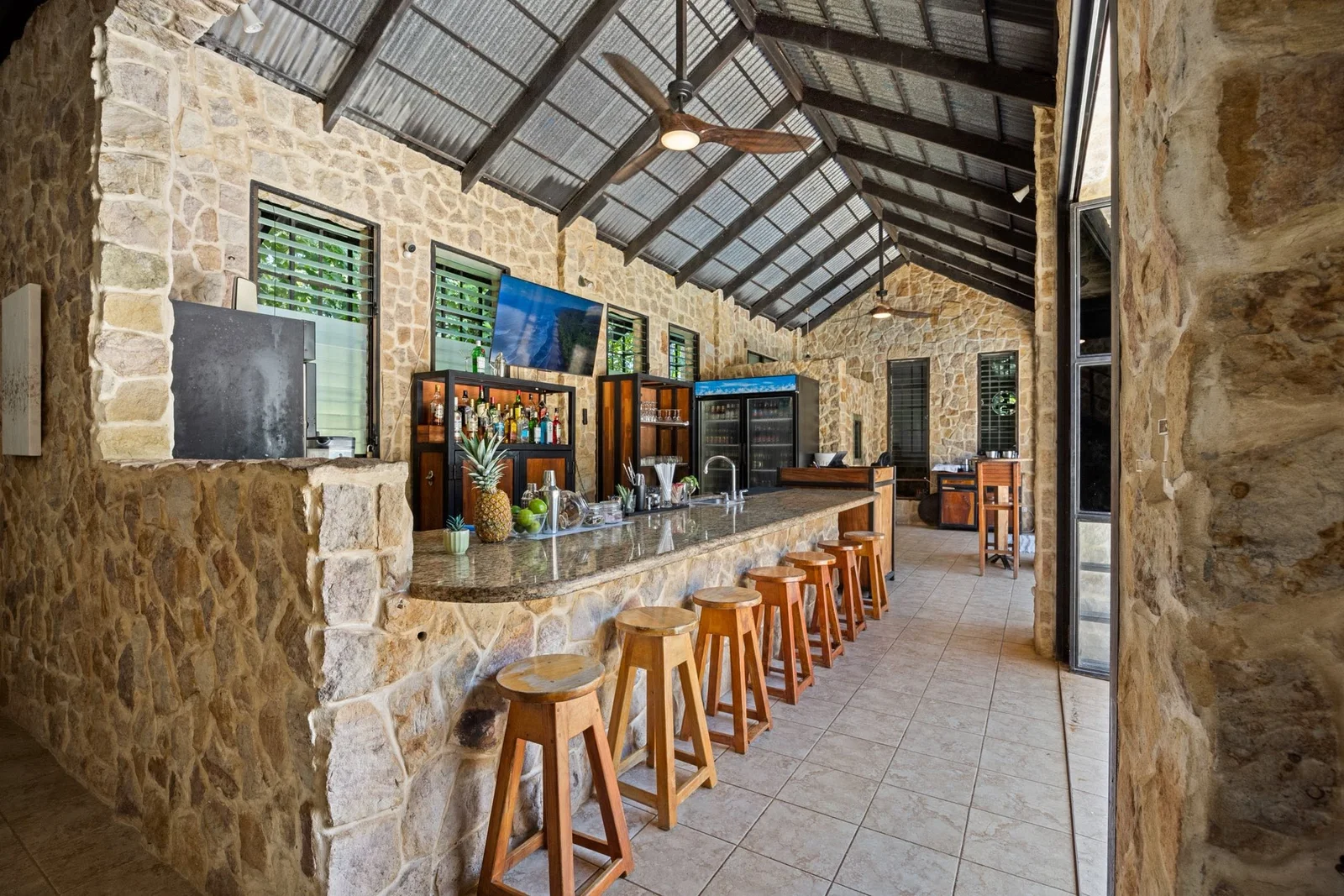 The Cactus bar with stone walls, a long counter and wooden stools
