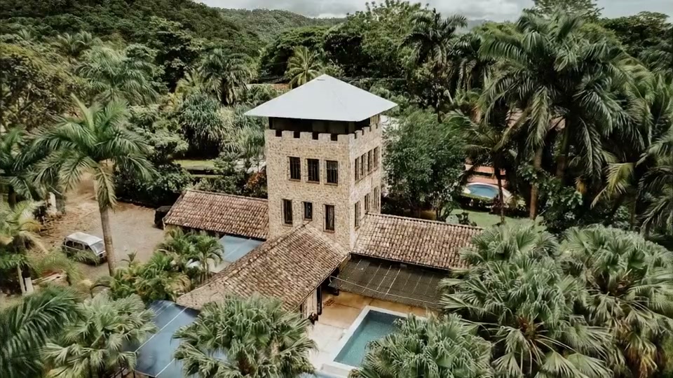 Aerial view of El Castillo’s stone tower surrounded by palms in Tambor